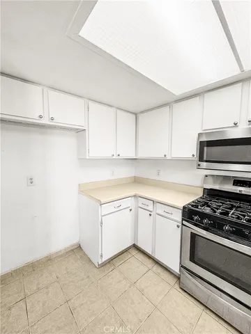 a kitchen with granite countertop white cabinets and white appliances