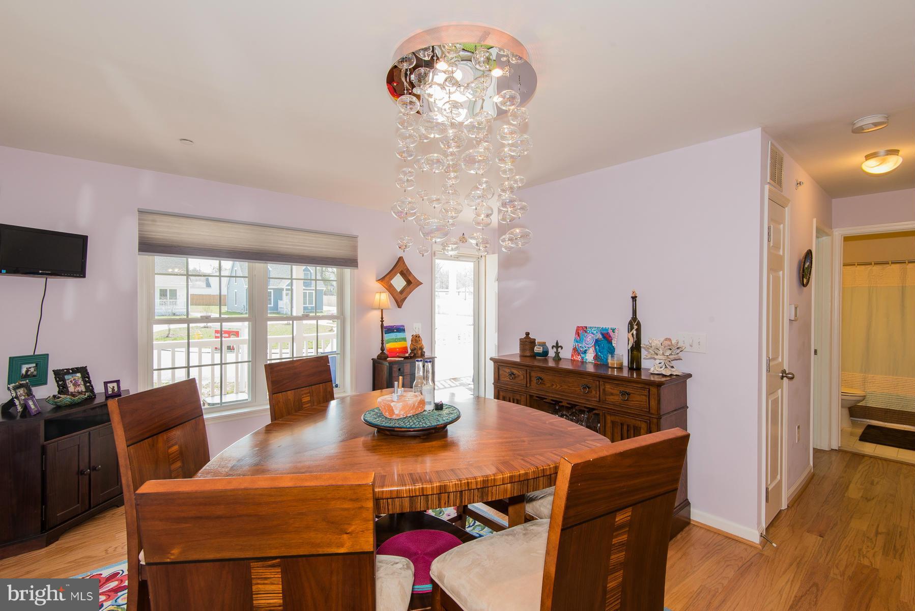 1325 Tree Side Court Odenton, MD 21113 - Photo 7 of 20 a view of a dining room with furniture a chandelier and wooden floor