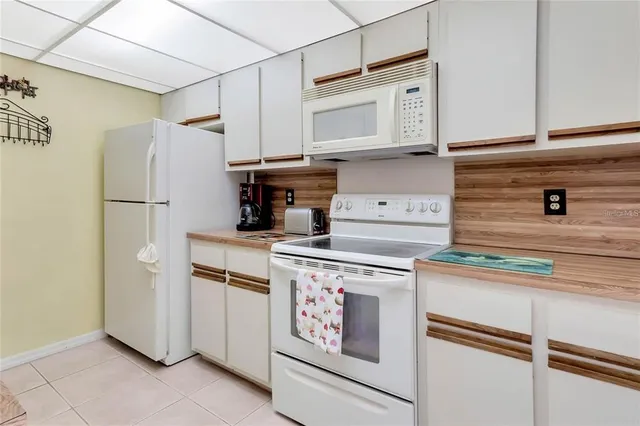 a kitchen with stainless steel appliances white cabinets and a refrigerator
