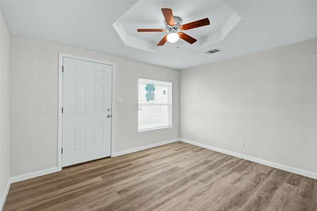 an empty room with wooden floor and windows