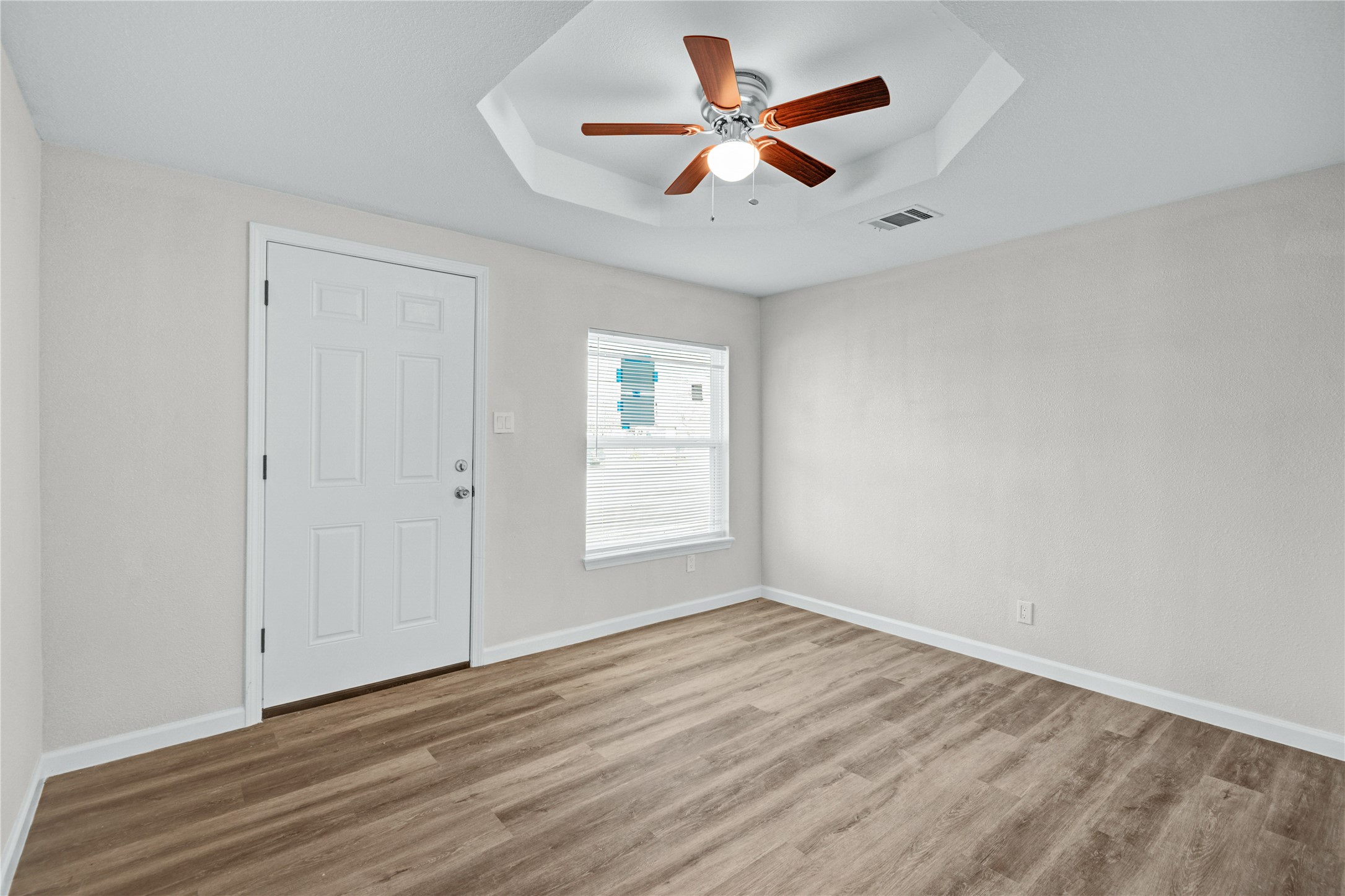 207 East Bernard Street Clute, TX 77531 - Photo 6 of 25 an empty room with wooden floor and windows