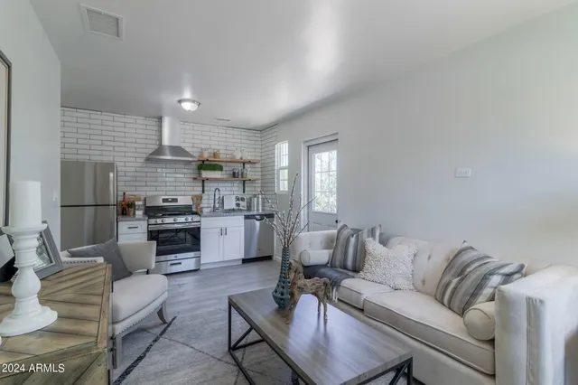 a living room with furniture and kitchen view