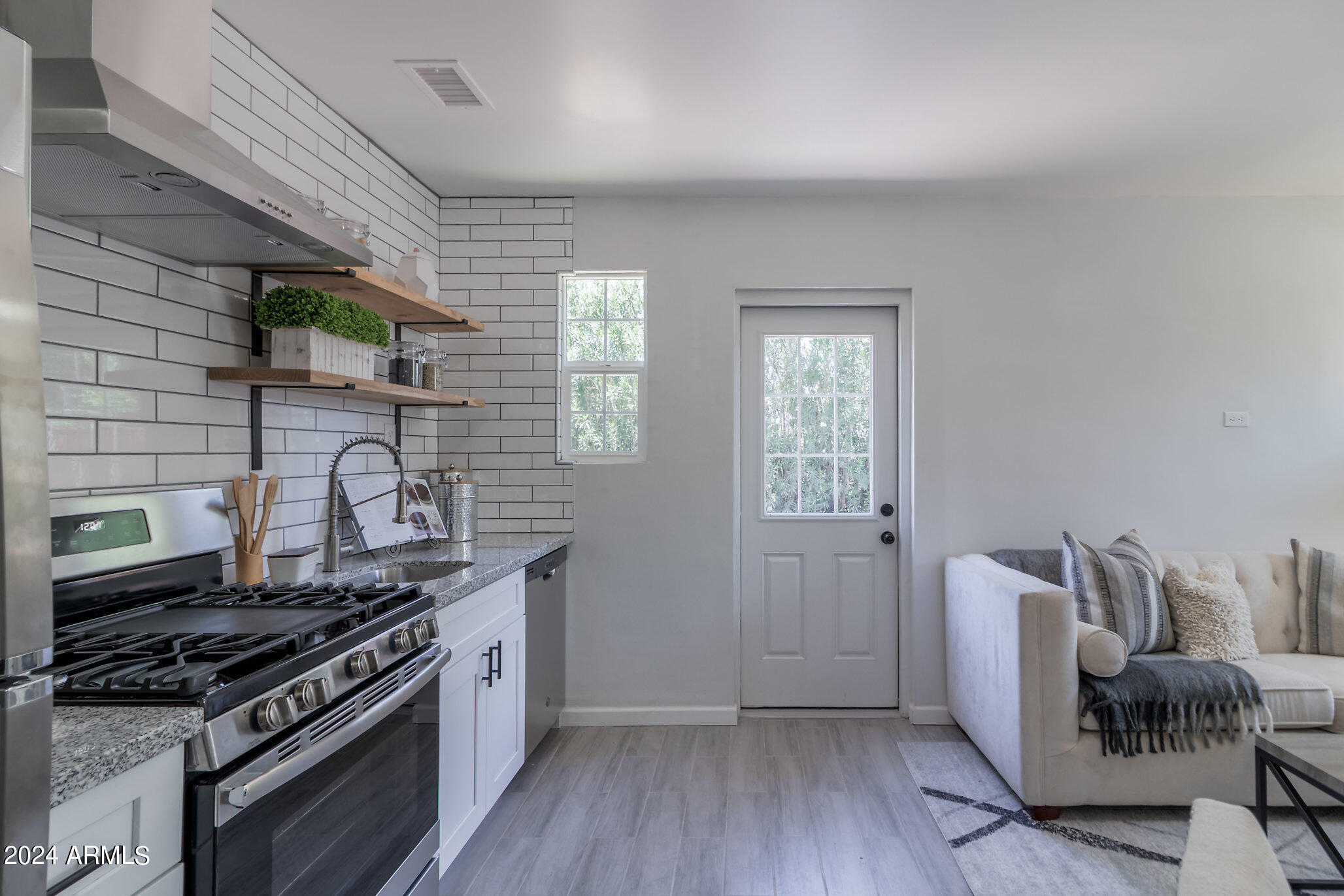 1649 East Oak Street, Unit 1 Phoenix, AZ 85006 - Photo 5 of 14 a kitchen with stainless steel appliances granite countertop a stove and a wooden floors