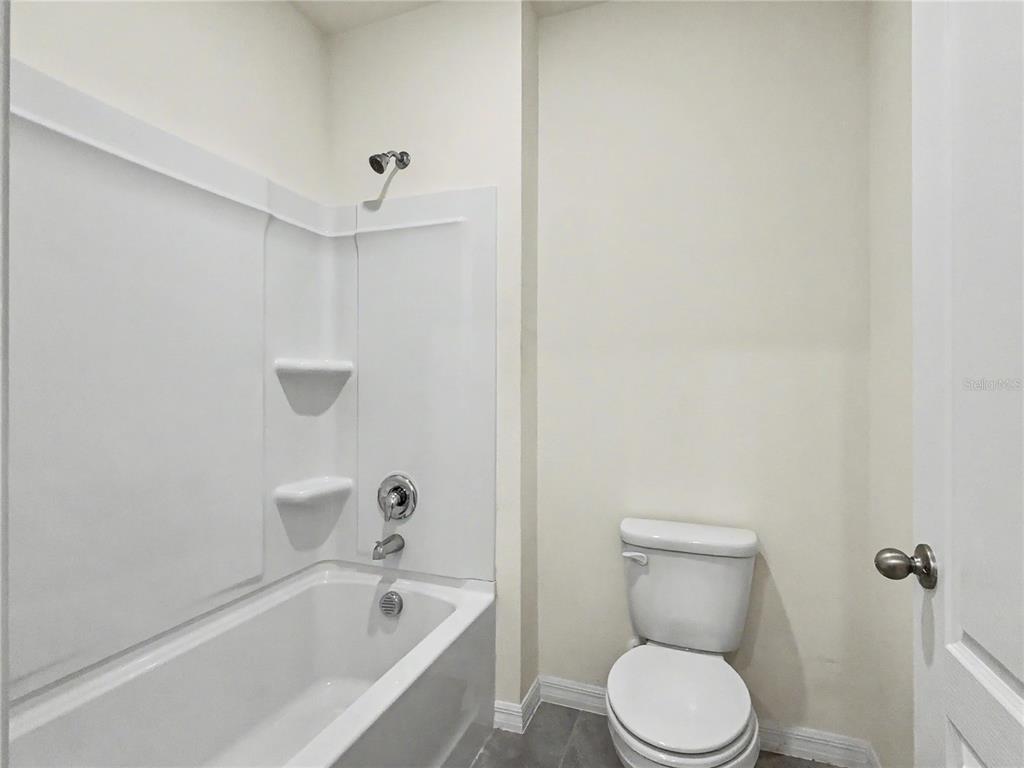 2085 Doe Run Drive Davenport, FL 33837 - Photo 41 of 44 a white toilet sitting next to a bath tub