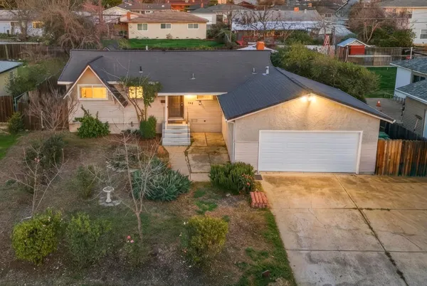 an aerial view of residential houses with outdoor space and trees