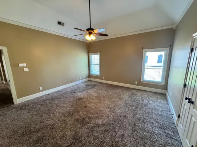 an empty room with a window and a fan
