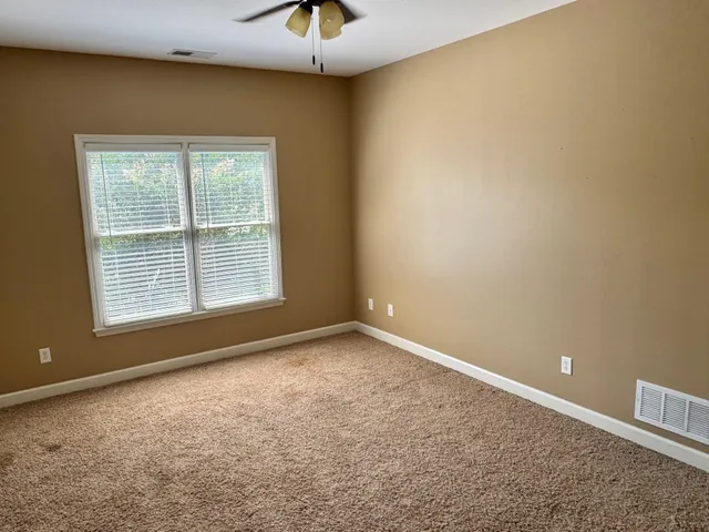 en empty room with windows and fan