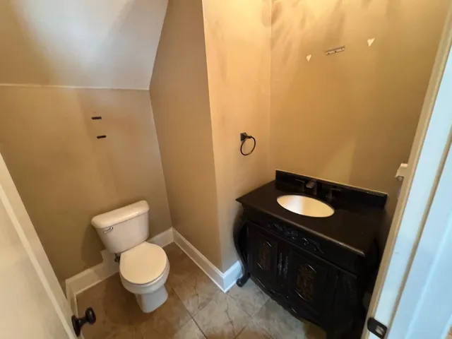 a bathroom with a granite countertop sink and a toilet