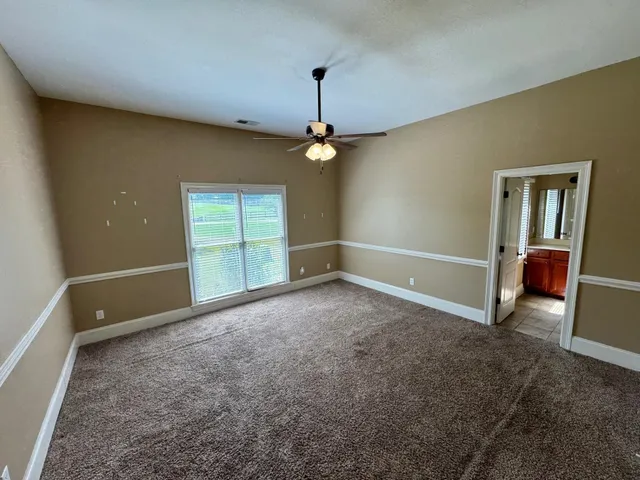 an empty room with windows and cabinet