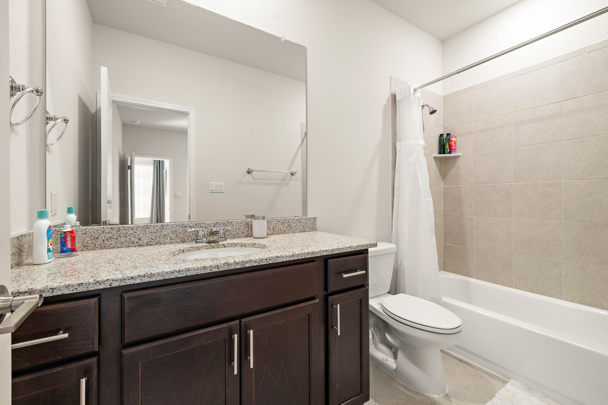 604 Spindrift Lane Leander, TX 78641 - Photo 23 of 32 a bathroom with a granite countertop sink toilet a large mirror a shower and a bathtub