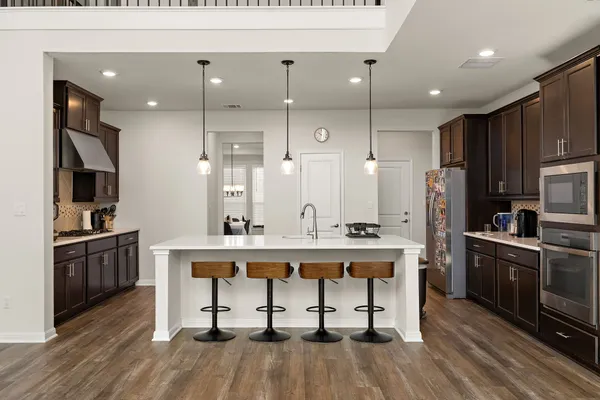 a view of kitchen with cabinets stainless steel appliances and wooden floor