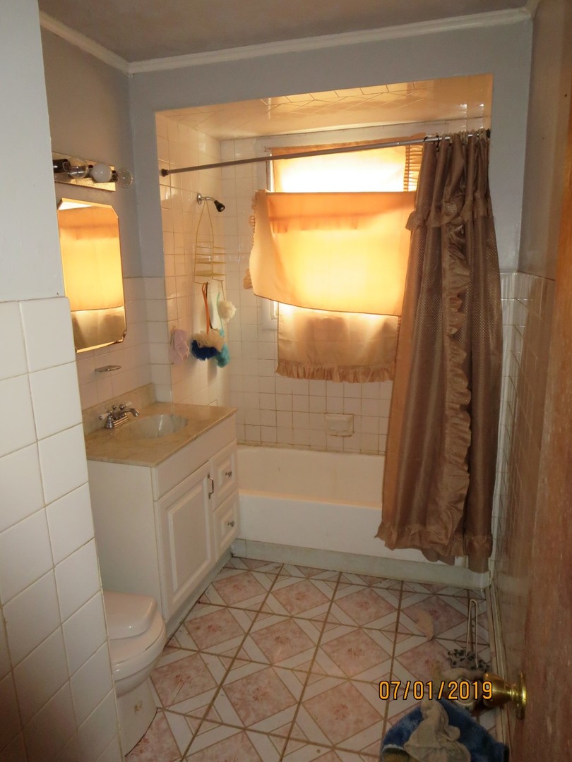 12756 South Racine Avenue Chicago, IL 60827 - Photo 8 of 11 a bathroom with a sink and a mirror