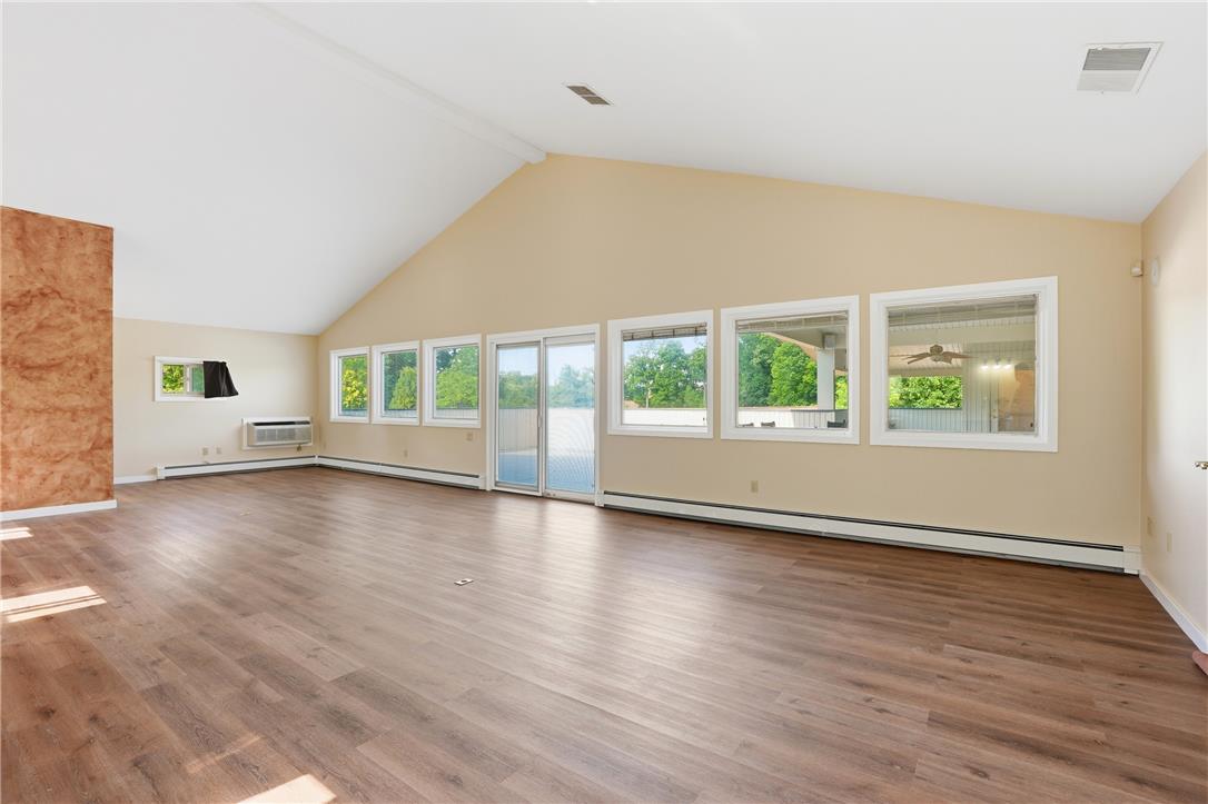 6271 Batman Road Zionsville, PA 18092 - Photo 78 of 100 A spacious living area features rich hardwood flooring and large windows, bathing the room in natural light.