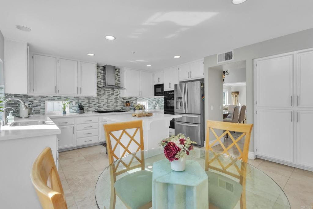 10403 Valley Waters Drive Spring Valley, CA 91978 - Photo 16 of 40 a kitchen with stainless steel appliances kitchen island granite countertop a refrigerator and a stove top oven