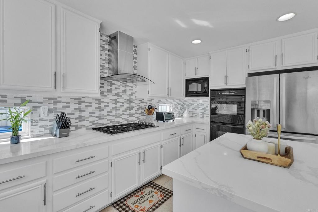 10403 Valley Waters Drive Spring Valley, CA 91978 - Photo 18 of 40 a kitchen with granite countertop a sink stainless steel appliances and white cabinets