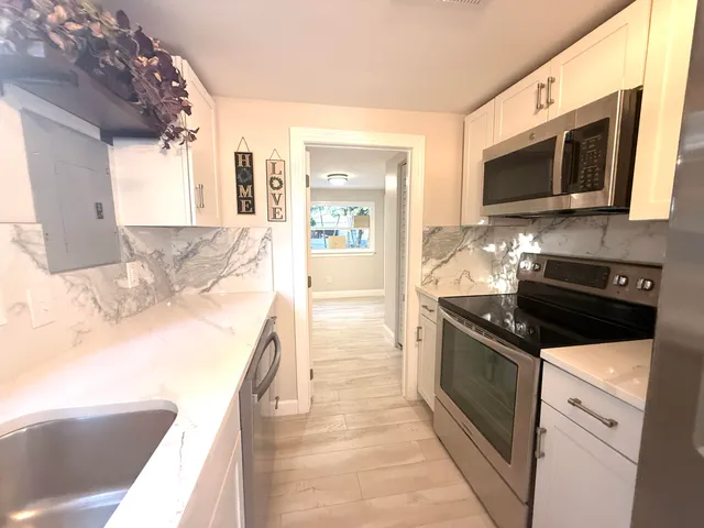 a kitchen with stainless steel appliances granite countertop a sink and a stove