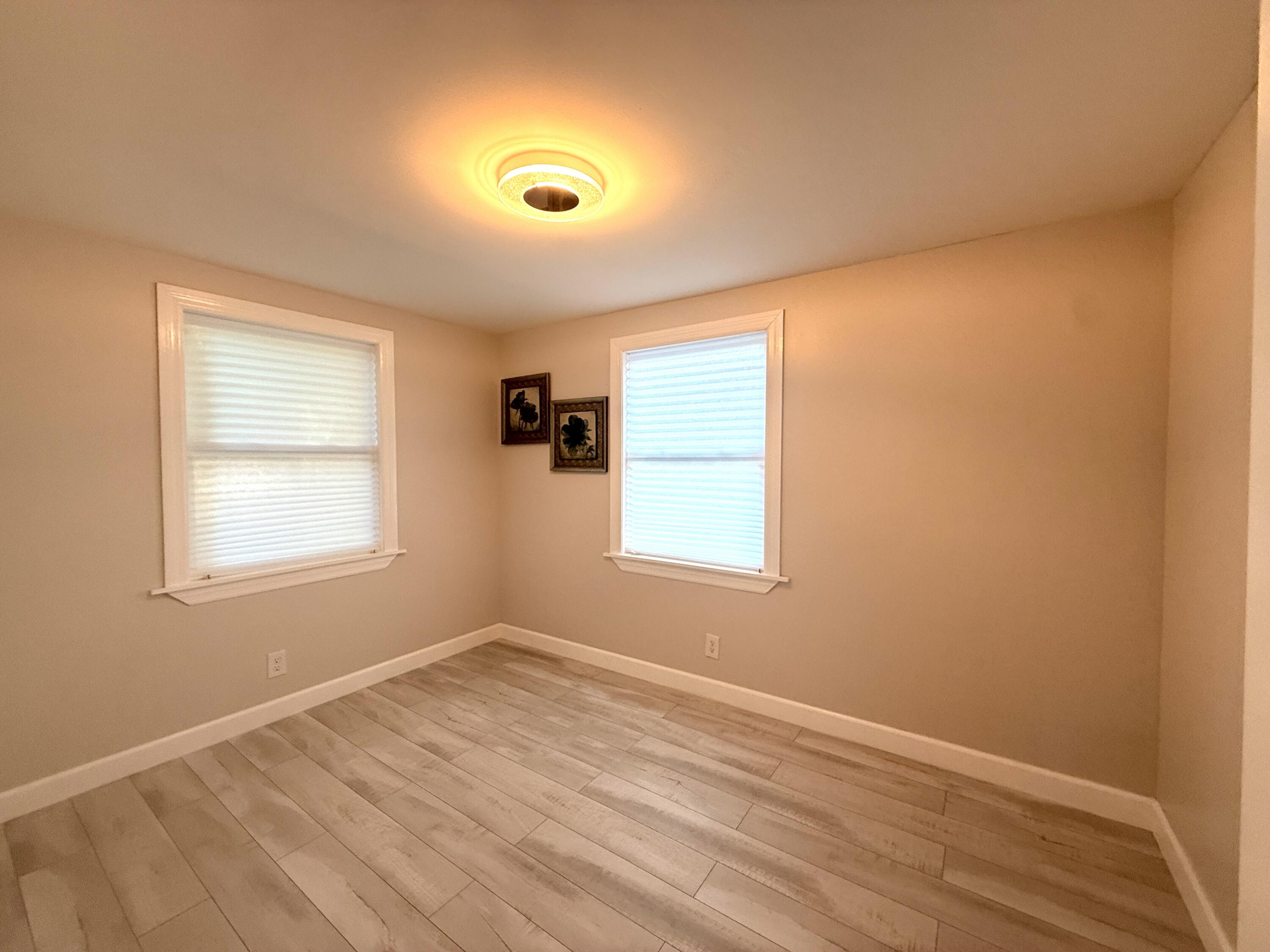 1093 Highview Road Lantana, FL 33462 - Photo 14 of 34 a view of an empty room with wooden floor and a window