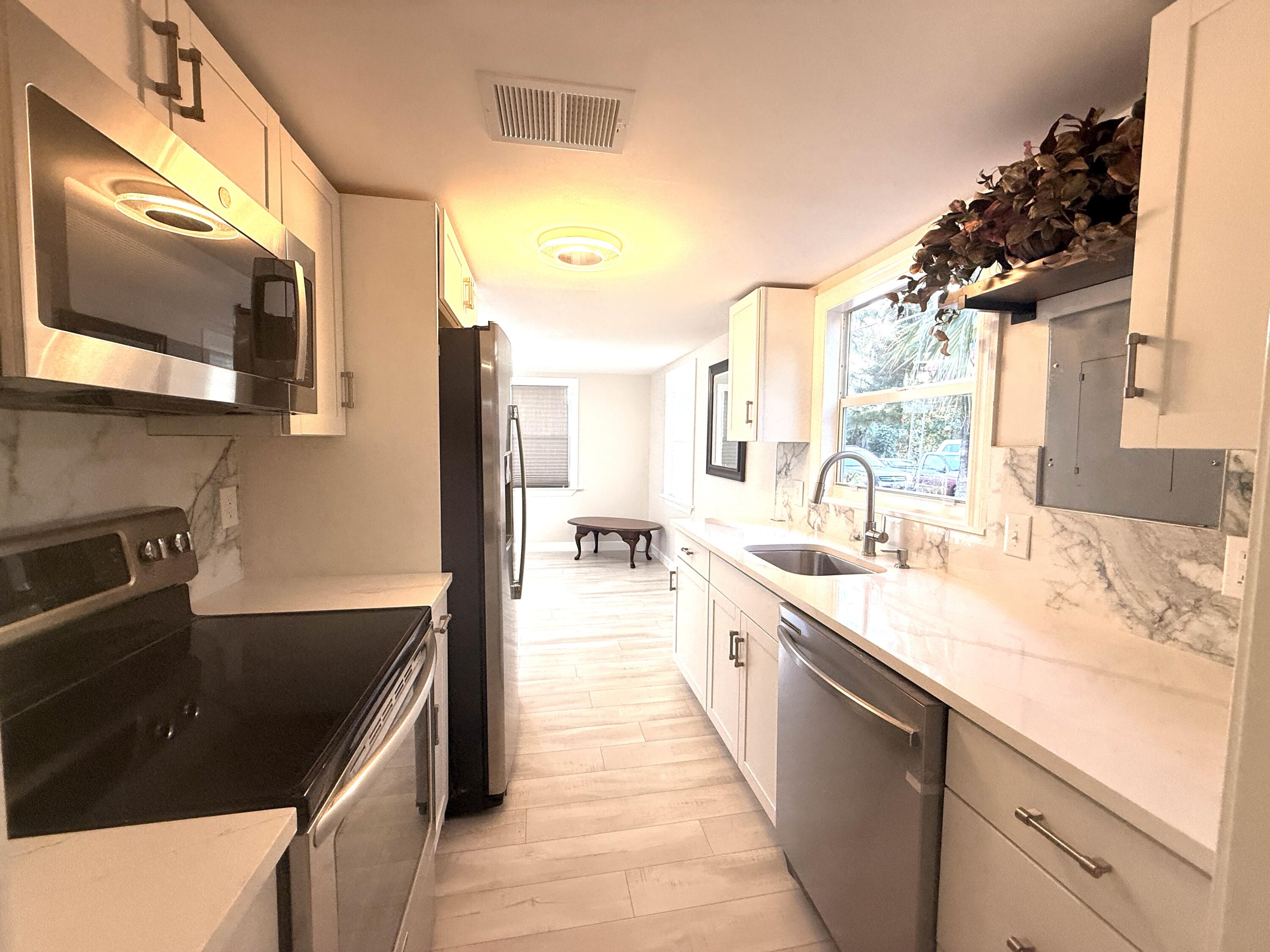 1093 Highview Road Lantana, FL 33462 - Photo 24 of 34 a kitchen with stainless steel appliances granite countertop a sink and a stove