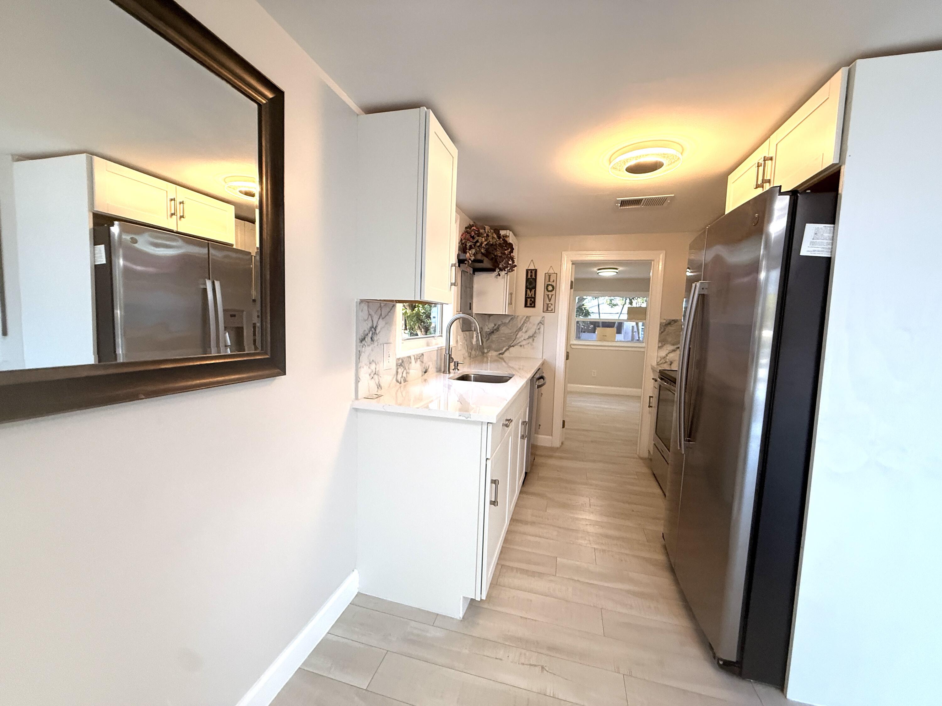 1093 Highview Road Lantana, FL 33462 - Photo 27 of 34 a view of a hallway with wooden floor and a living room