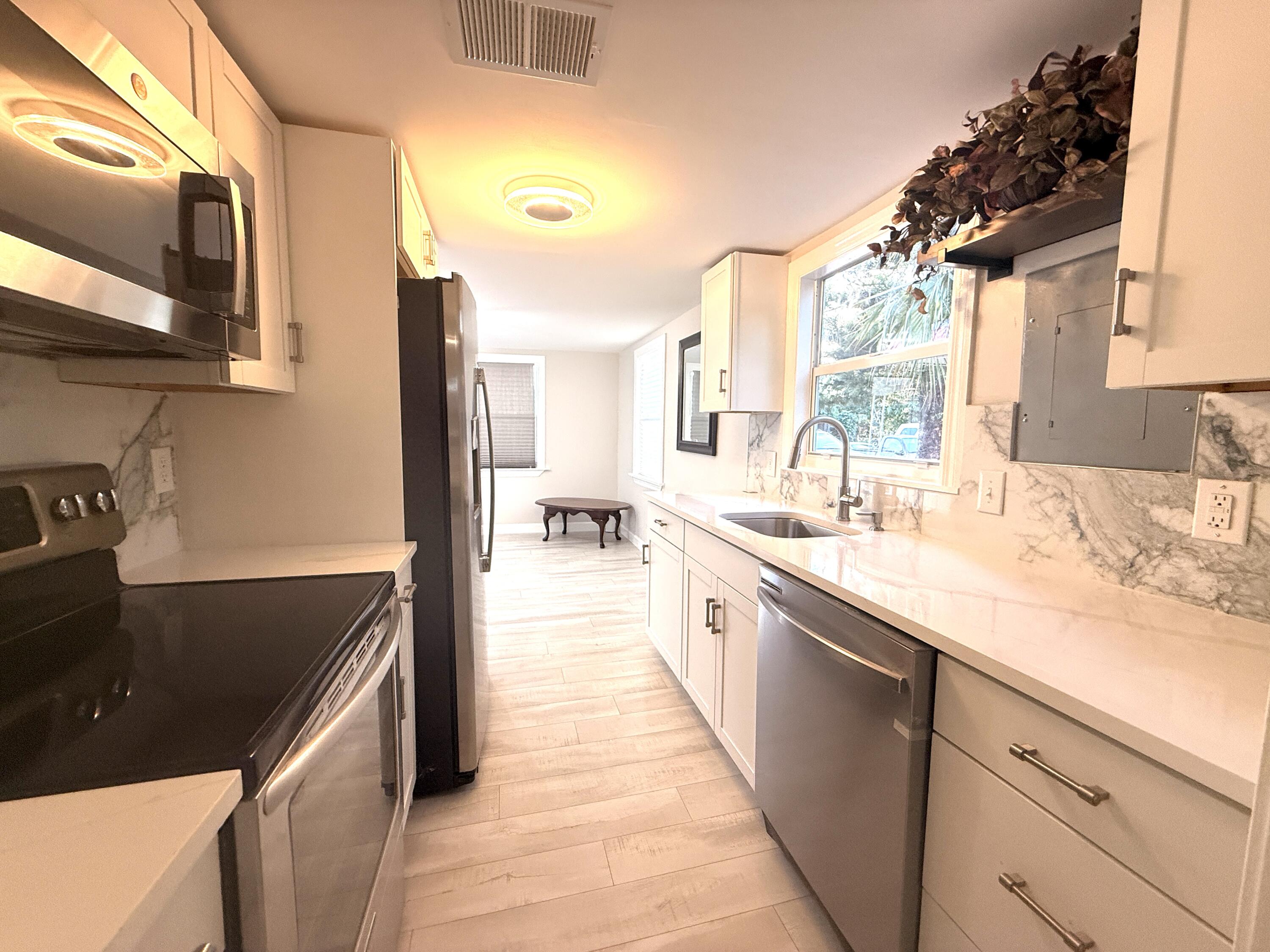 1093 Highview Road Lantana, FL 33462 - Photo 4 of 34 a kitchen with a sink and a stove top oven