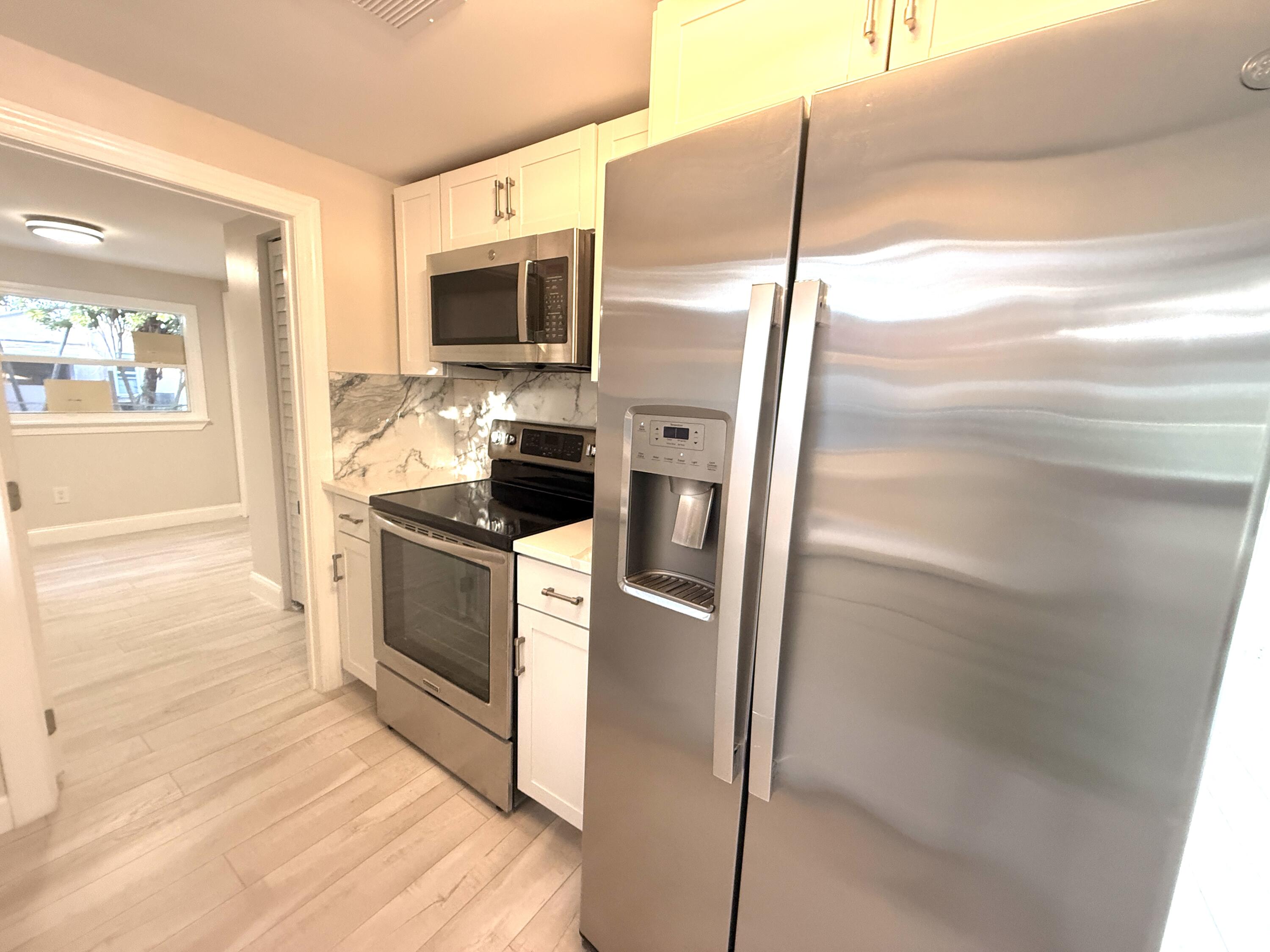 1093 Highview Road Lantana, FL 33462 - Photo 8 of 34 a kitchen with cabinets and steel stainless steel appliances