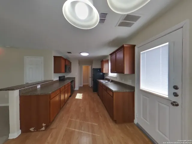 a kitchen with stainless steel appliances granite countertop a stove and a wooden floors