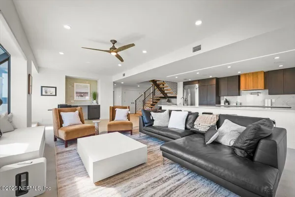 a kitchen with stainless steel appliances granite countertop a sink a stove a refrigerator and island with wooden floor