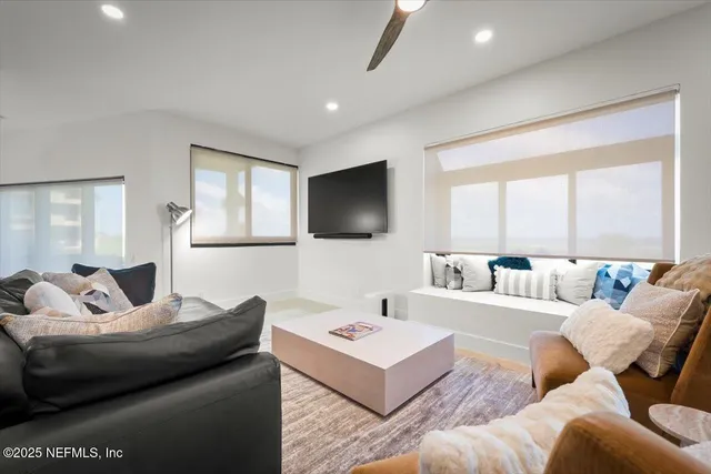 a bedroom with a bed lamp and a ceiling fan