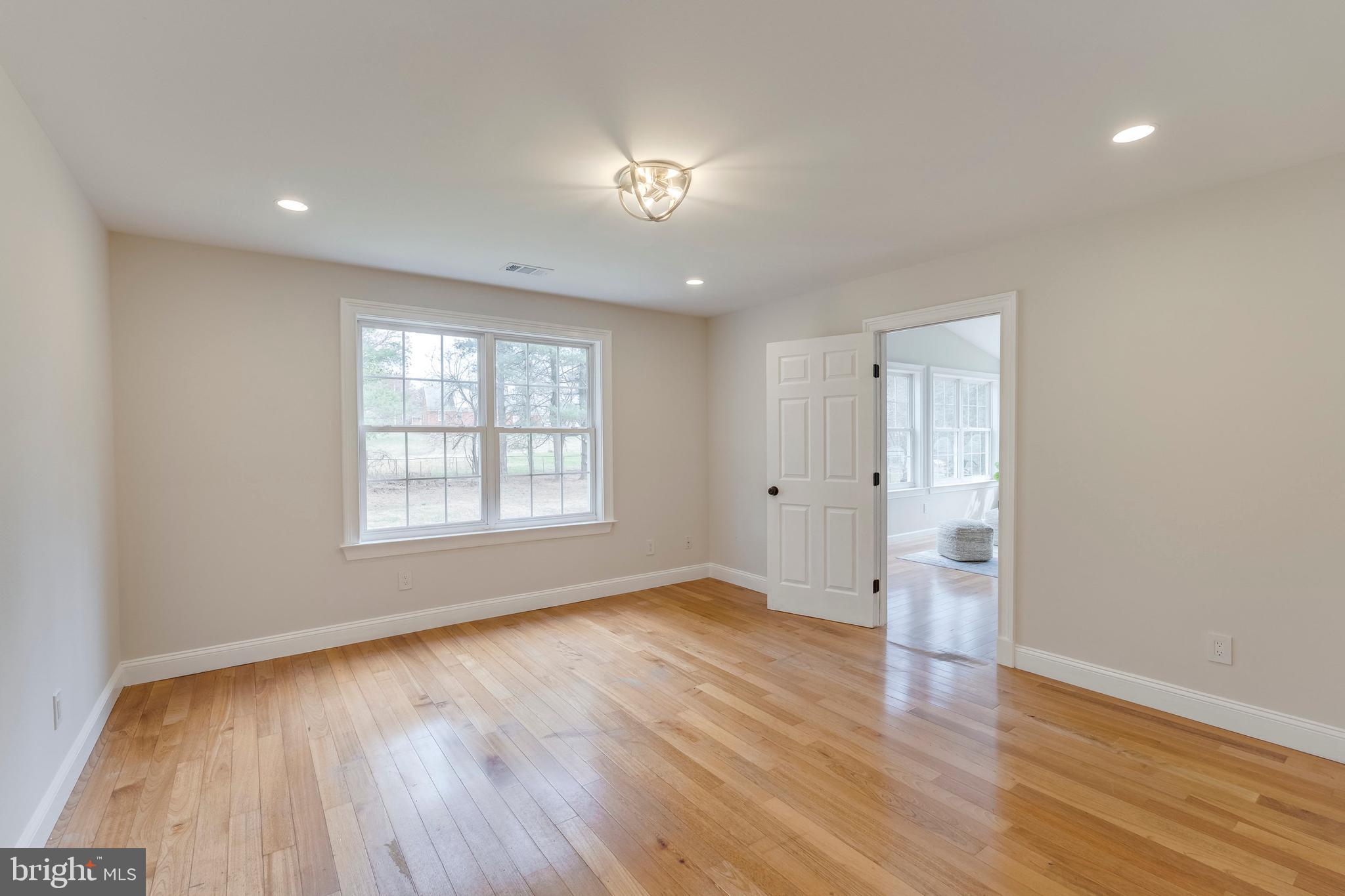 15001 Peach Orchard Road Silver Spring, MD 20905 - Photo 26 of 63 an empty room with wooden floor and windows