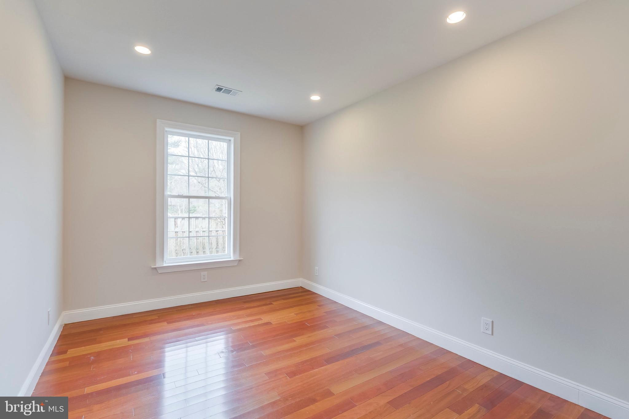 15001 Peach Orchard Road Silver Spring, MD 20905 - Photo 44 of 63 an empty room with wooden floor and windows
