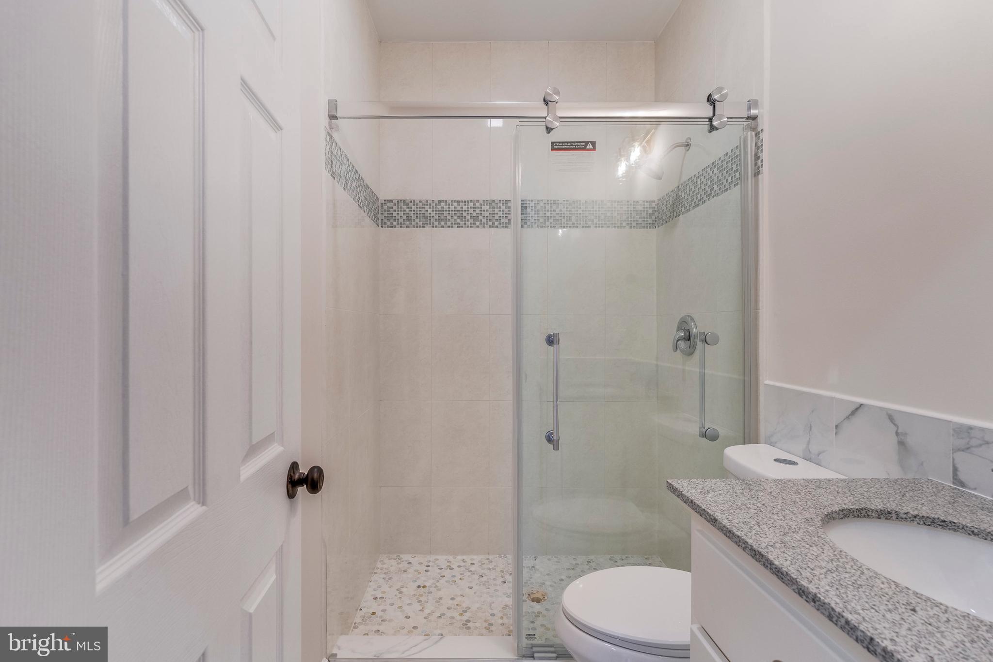 15001 Peach Orchard Road Silver Spring, MD 20905 - Photo 45 of 63 a bathroom with a granite countertop sink toilet and shower
