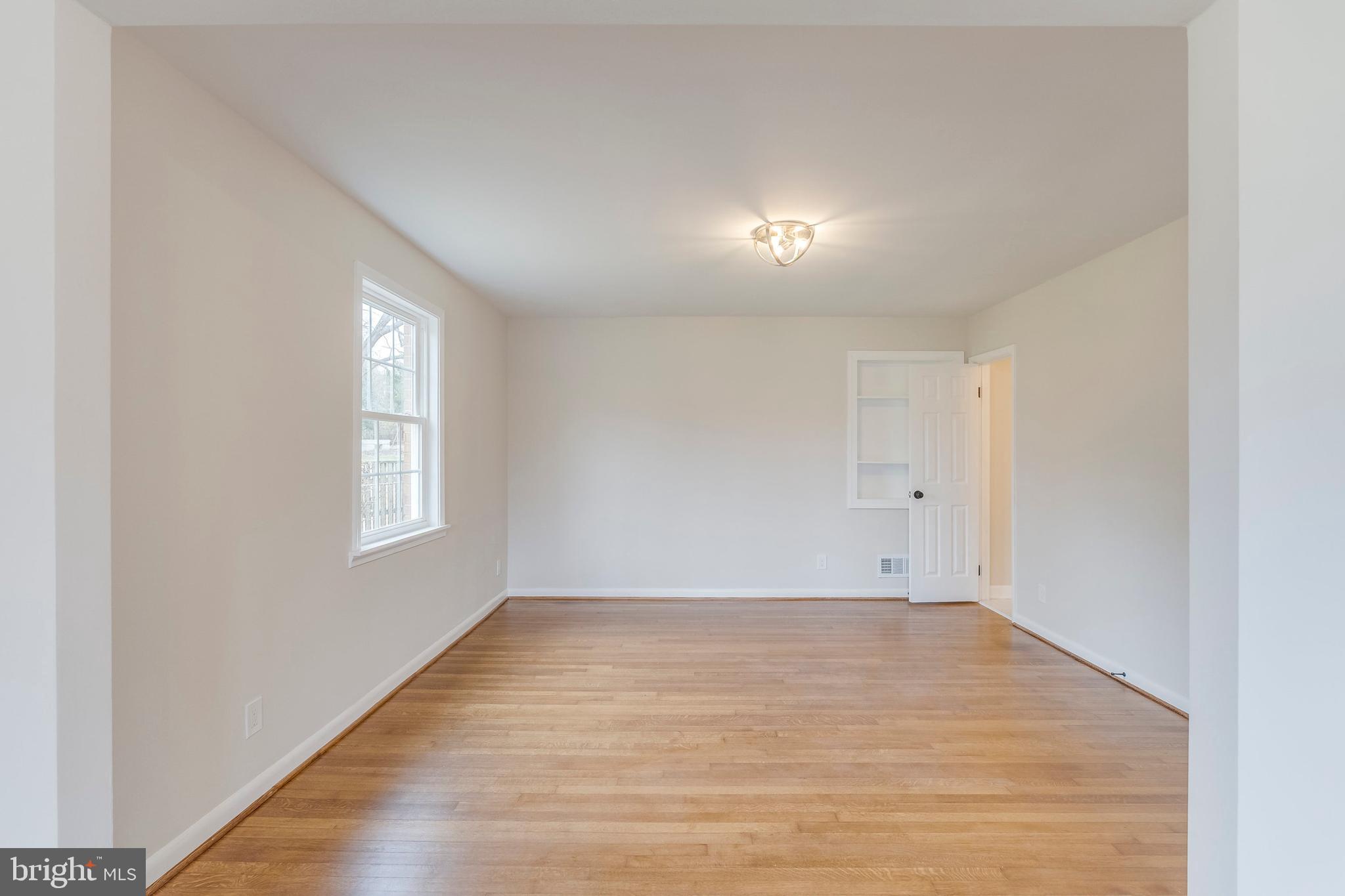 15001 Peach Orchard Road Silver Spring, MD 20905 - Photo 49 of 63 an empty room with wooden floor and windows