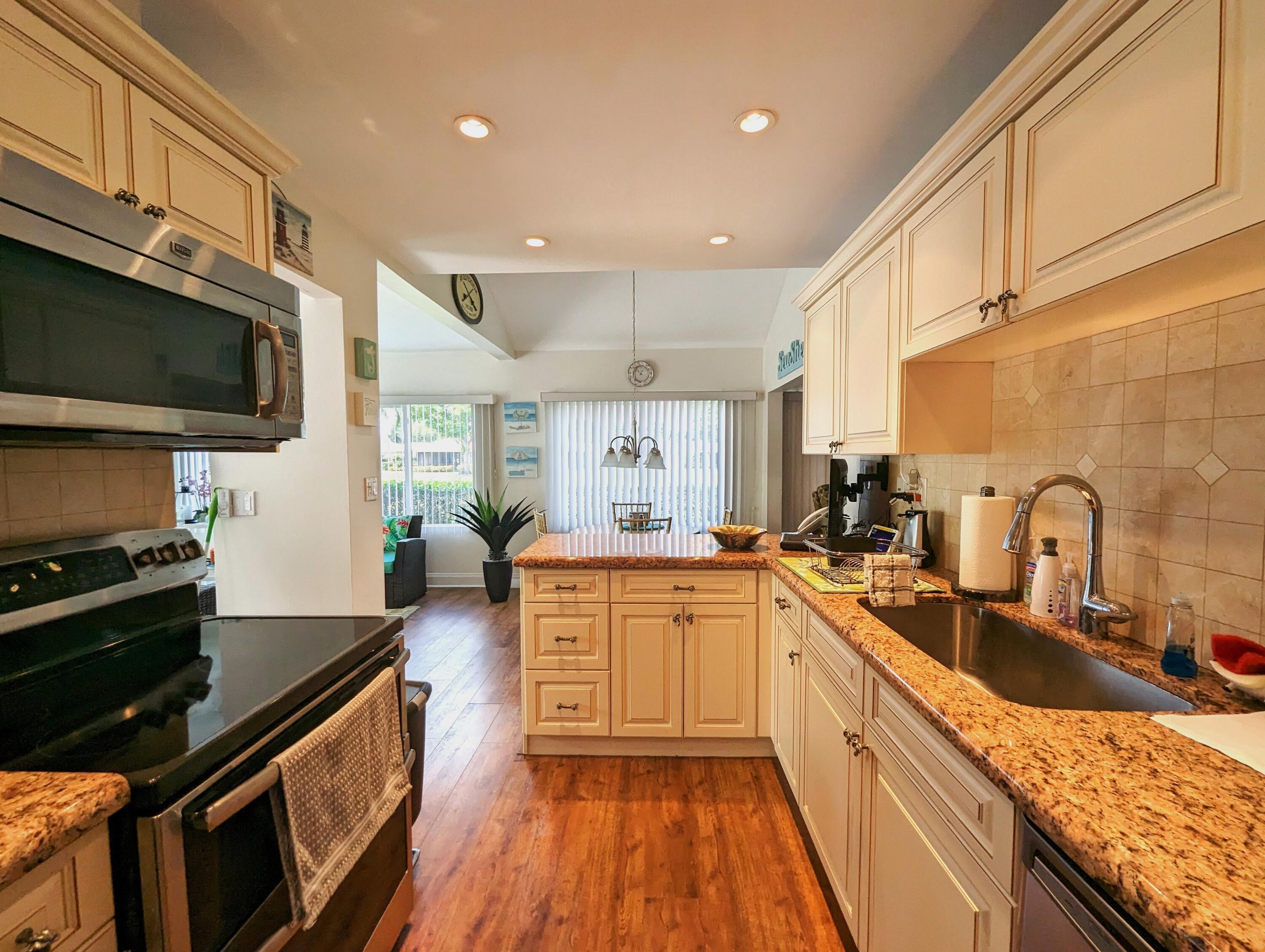 17042 Traverse Circle Jupiter, FL 33477 - Photo 10 of 30 a kitchen with stainless steel appliances granite countertop a sink stove and refrigerator