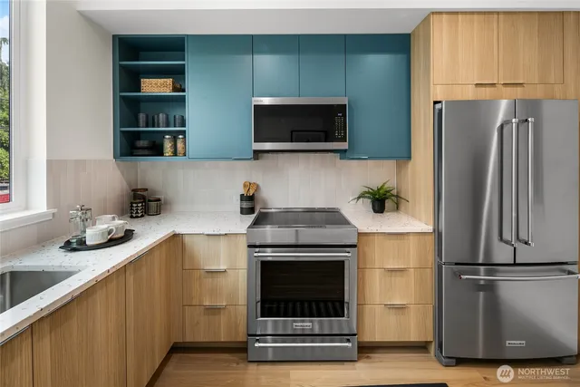 a kitchen with stainless steel appliances a stove a microwave and a refrigerator