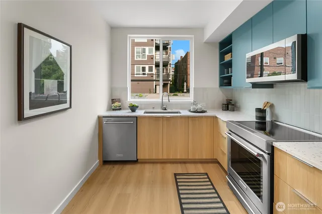 a kitchen with stainless steel appliances granite countertop a sink stove and cabinets