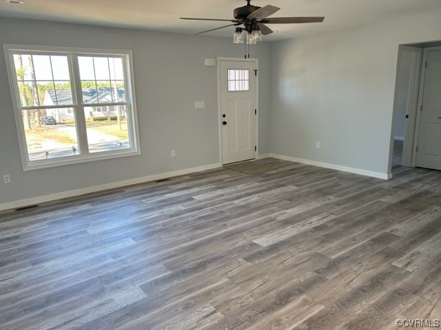 10234 Doyle Boulevard McKenney, VA 23872 - Photo 2 of 10 an empty room with wooden floor fan and windows