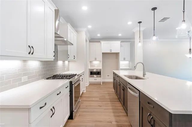 a kitchen with stainless steel appliances granite countertop a sink a stove and a refrigerator