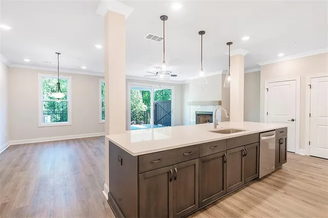 a kitchen with kitchen island granite countertop a sink a counter space appliances and a window