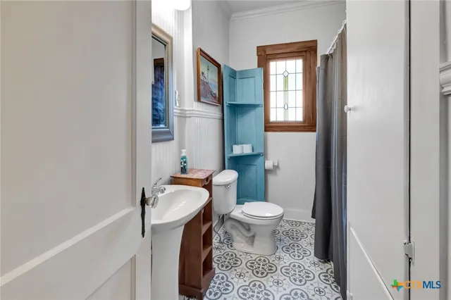 a bathroom with a sink toilet and a mirror
