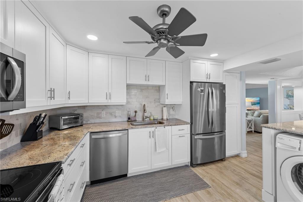 105 Penny Lane, Unit 5 Naples, FL 34112 - Photo 13 of 50 a kitchen with a sink a refrigerator a washer and dryer