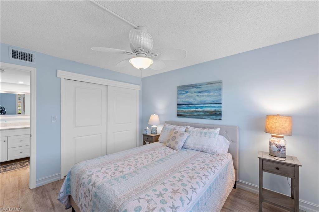 105 Penny Lane, Unit 5 Naples, FL 34112 - Photo 20 of 50 a bedroom with a bed and a lamp on table