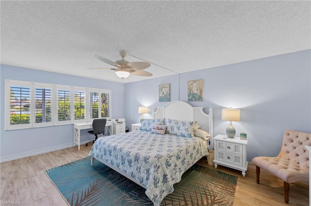 105 Penny Lane, Unit 5 Naples, FL 34112 - Photo 23 of 50 a bedroom with a bed wooden floor and lamp