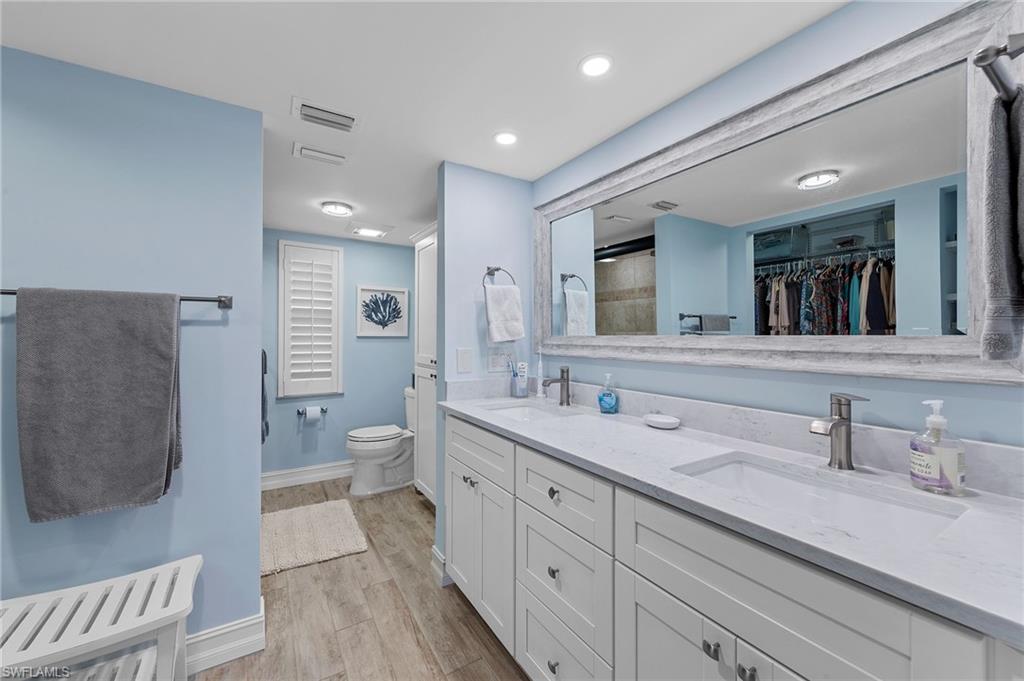 105 Penny Lane, Unit 5 Naples, FL 34112 - Photo 26 of 50 a spacious bathroom with a double vanity sink a mirror and a toilet