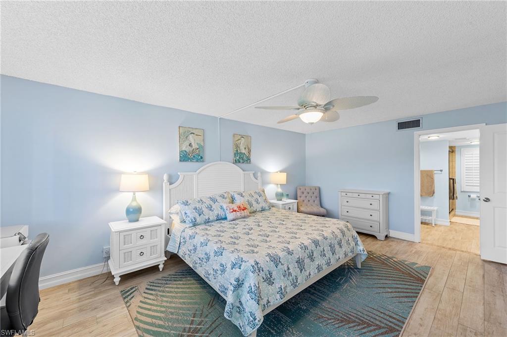 105 Penny Lane, Unit 5 Naples, FL 34112 - Photo 27 of 50 a bedroom with a bed and wooden floor