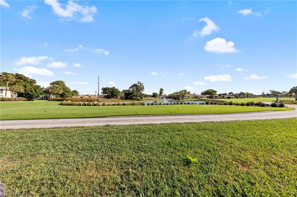 105 Penny Lane, Unit 5 Naples, FL 34112 - Photo 33 of 50 a view of a golf course with a lake