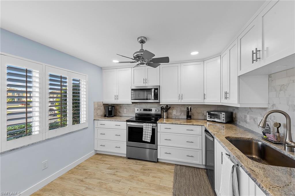 105 Penny Lane, Unit 5 Naples, FL 34112 - Photo 10 of 50 a kitchen with stainless steel appliances granite countertop a sink a stove a refrigerator cabinets and a window
