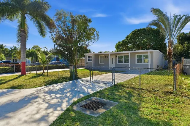 a view of a house with backyard and tree