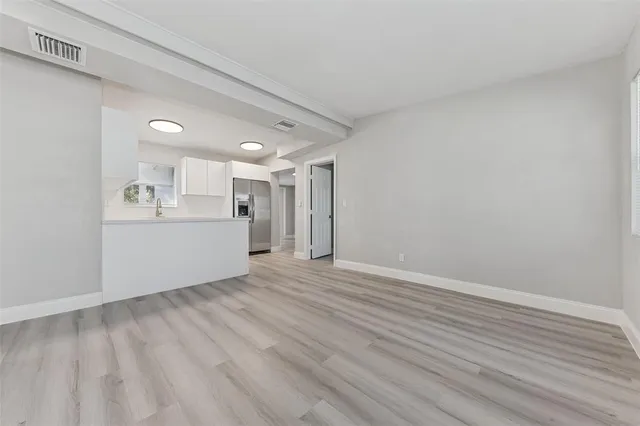 a view of a kitchen with wooden floor and windows