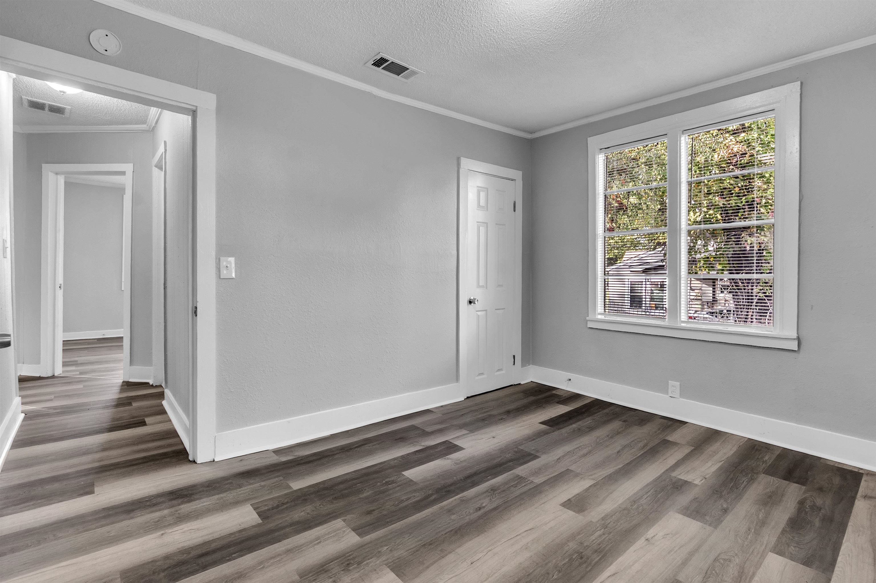 2442 Manchester Road Memphis, TN 38114 - Photo 12 of 22 a view of an empty room with wooden floor and a window