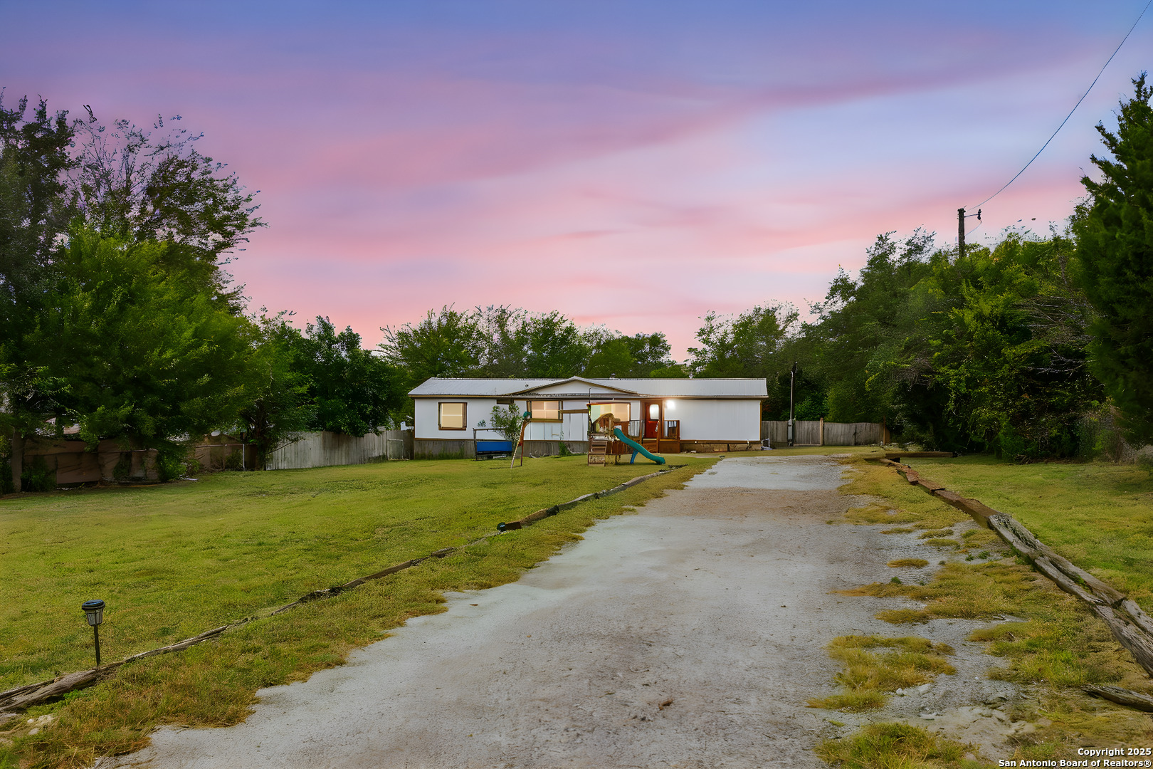 a front view of a house with a yard and trees